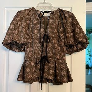 puff sleeve blouse with bow details on the front and a zipper on the back.